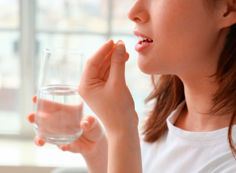 Mujer tomando cásula